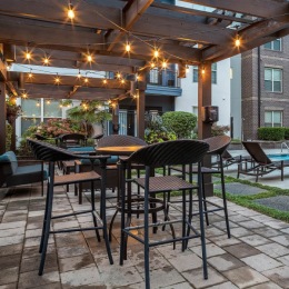 outdoor seating area with tables and chairs and string lights hanging above