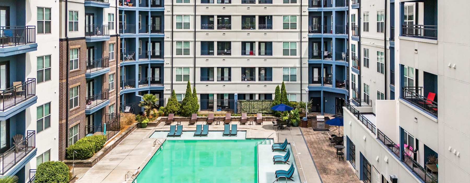 aerial view of a pool in a courtyard with lounge chairs